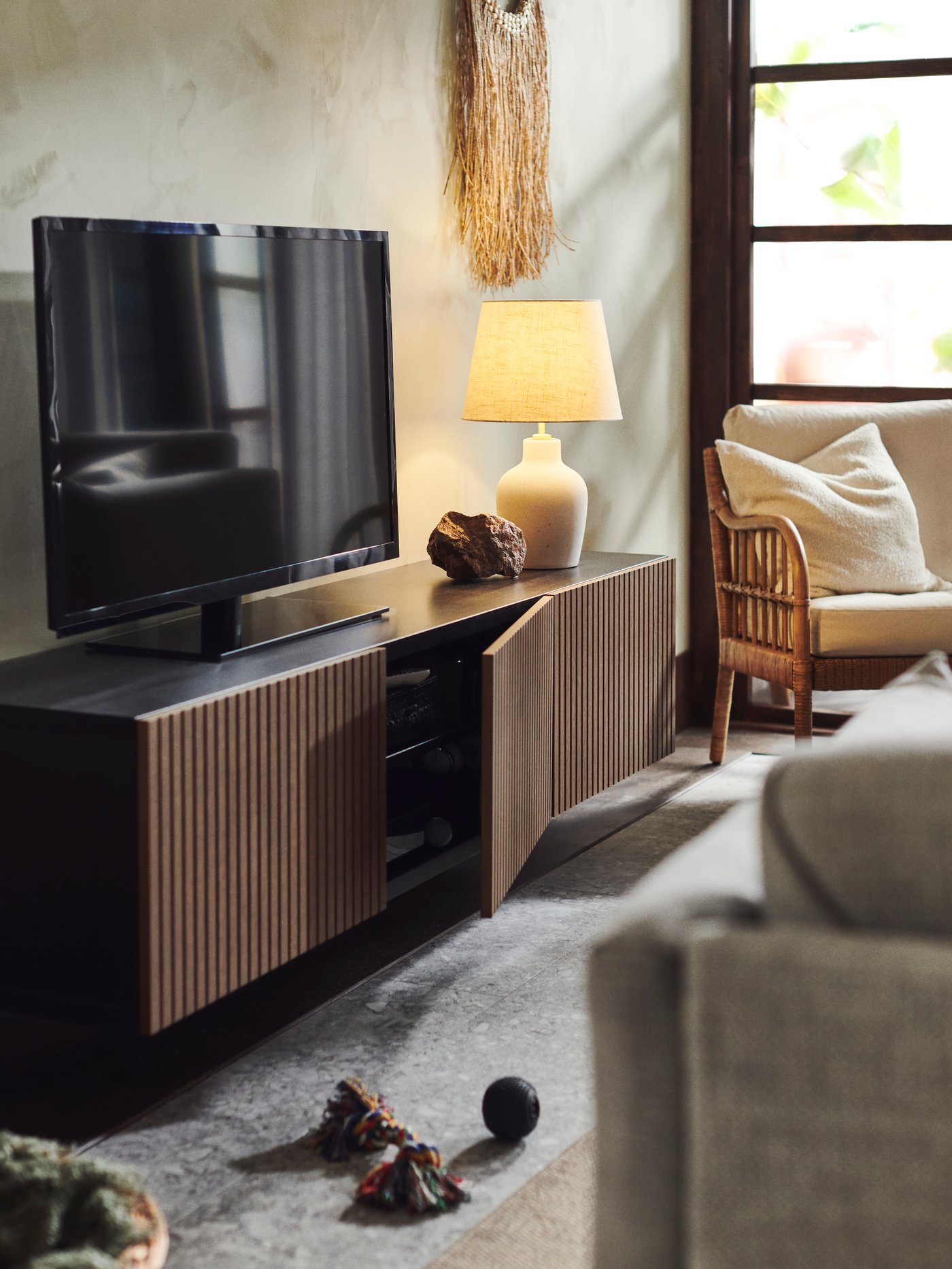 In einem Wohnraum steht ein Fernseher auf einer TV-Bank.