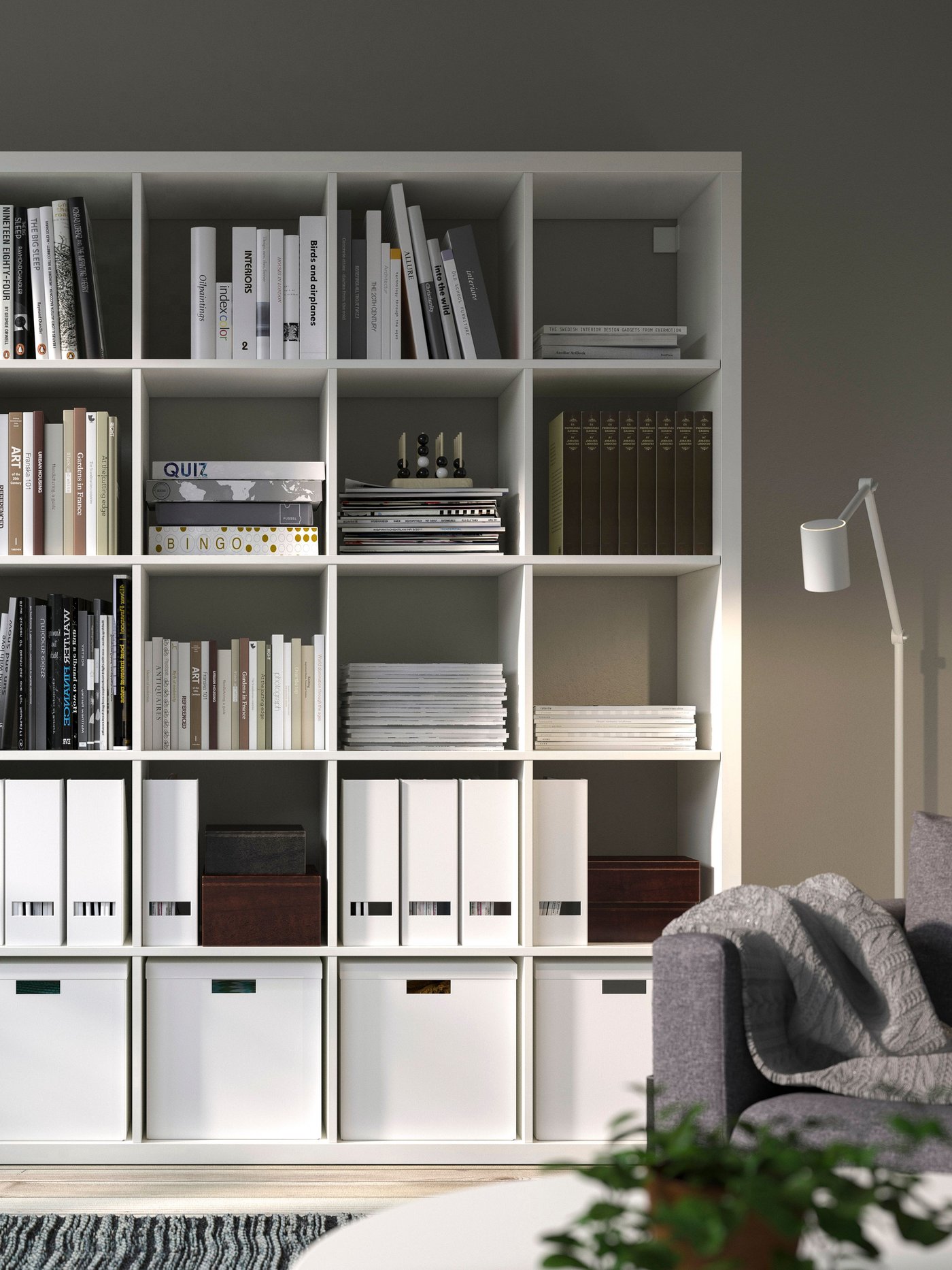 A white KALLAX shelving unit white insert storage boxes in a living room.