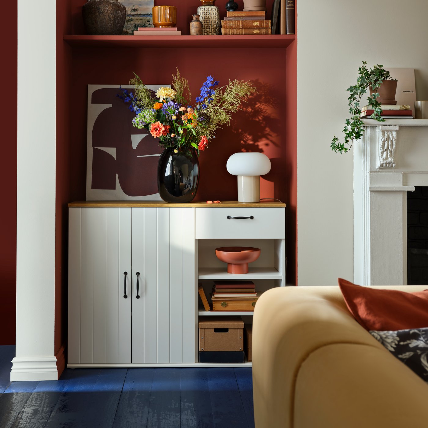 Dans une pièce élégante, un buffet SKRUVBY blanc comportant deux armoires et un tiroir, décoré avec des fleurs et un vase.