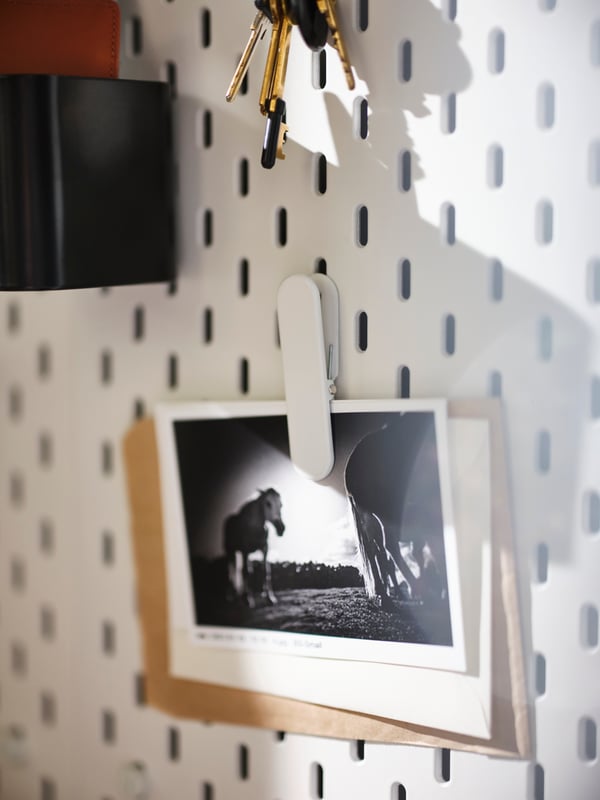 SKÅDIS memo board with photos clipped on it. Above it is a set of keys.