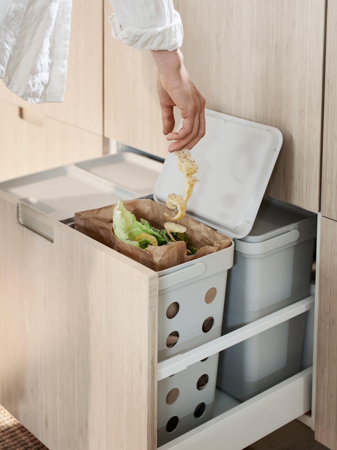 A light grey HÅLLBAR bin with lid in the kitchen