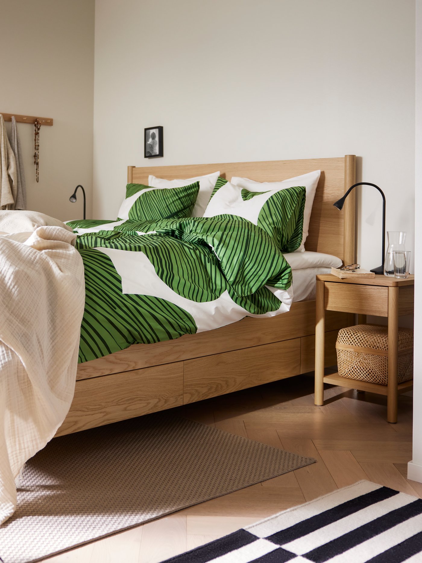 An oak veneer TONSTAD bed frame with storage