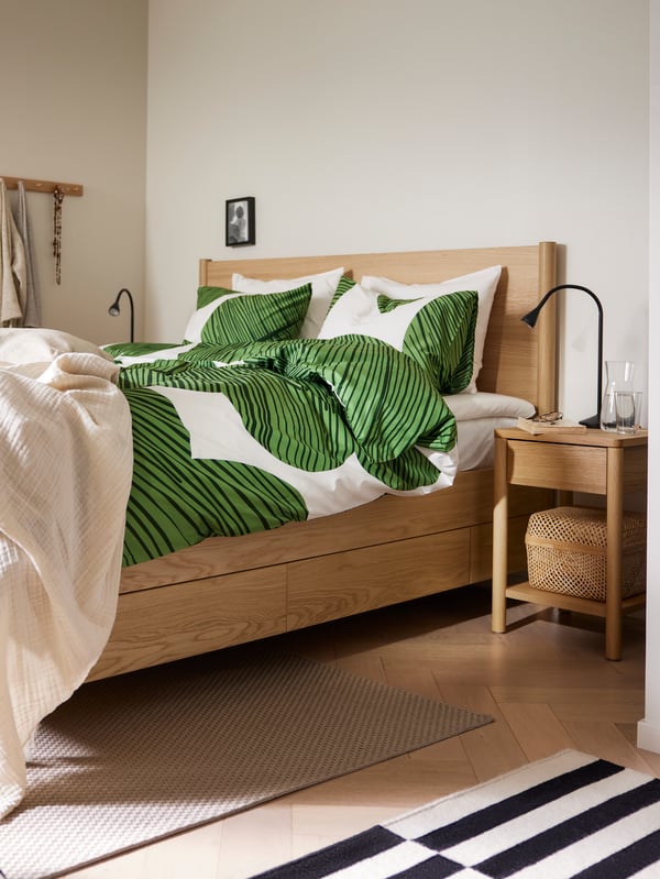 An oak veneer TONSTAD bed frame with storage