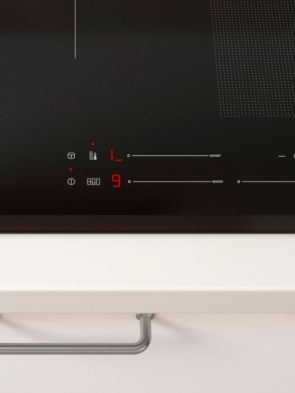 A close-up of an induction hob’s touch sensor controls showing the pre-set cooking mode.