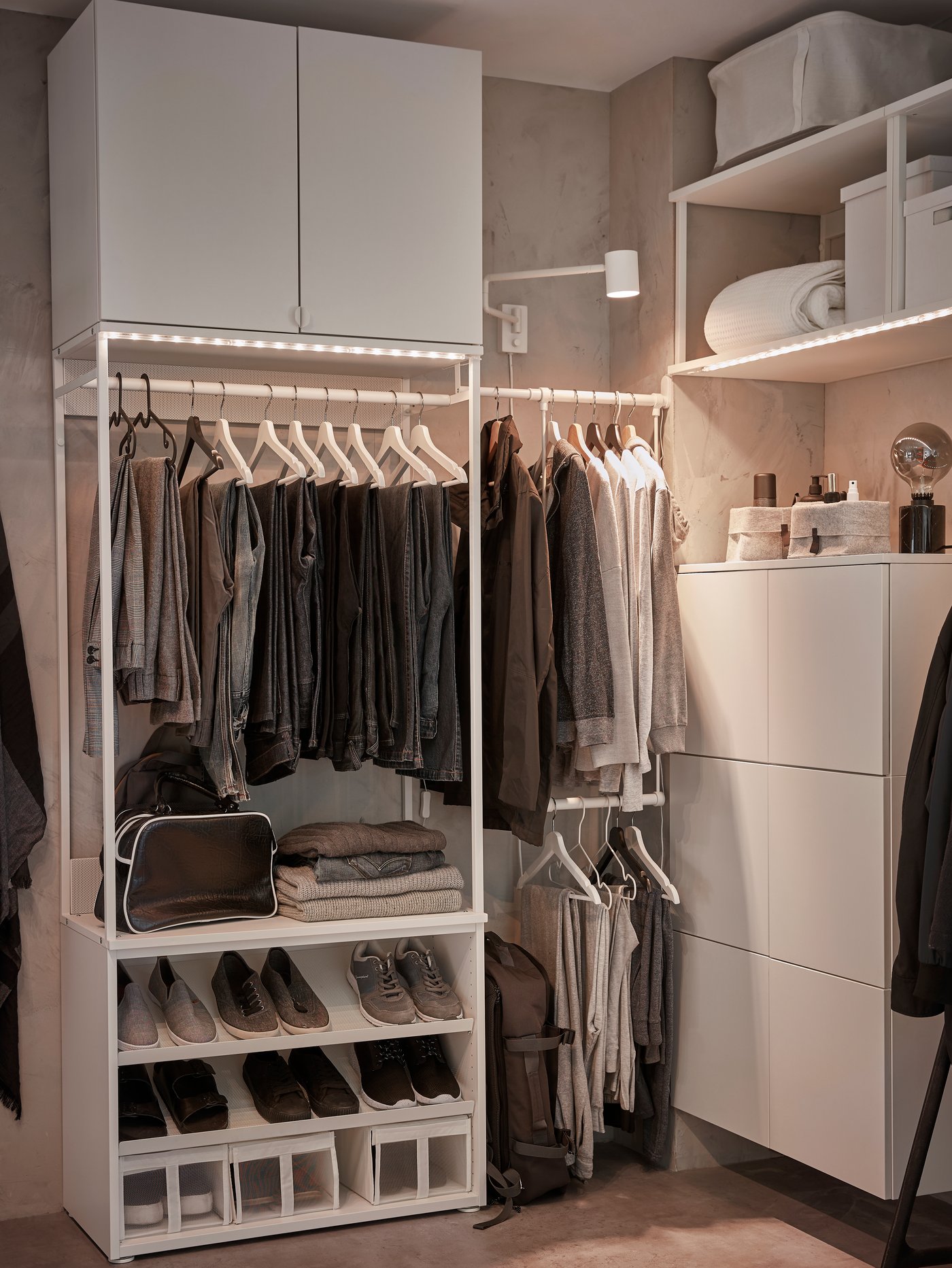 A white PLATSA wardrobe, with clothes rails, shoe shelves, lighting strips and boxes, and white PLATSA wall storage.
