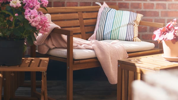 A pale pink INGABRITTA throw outside