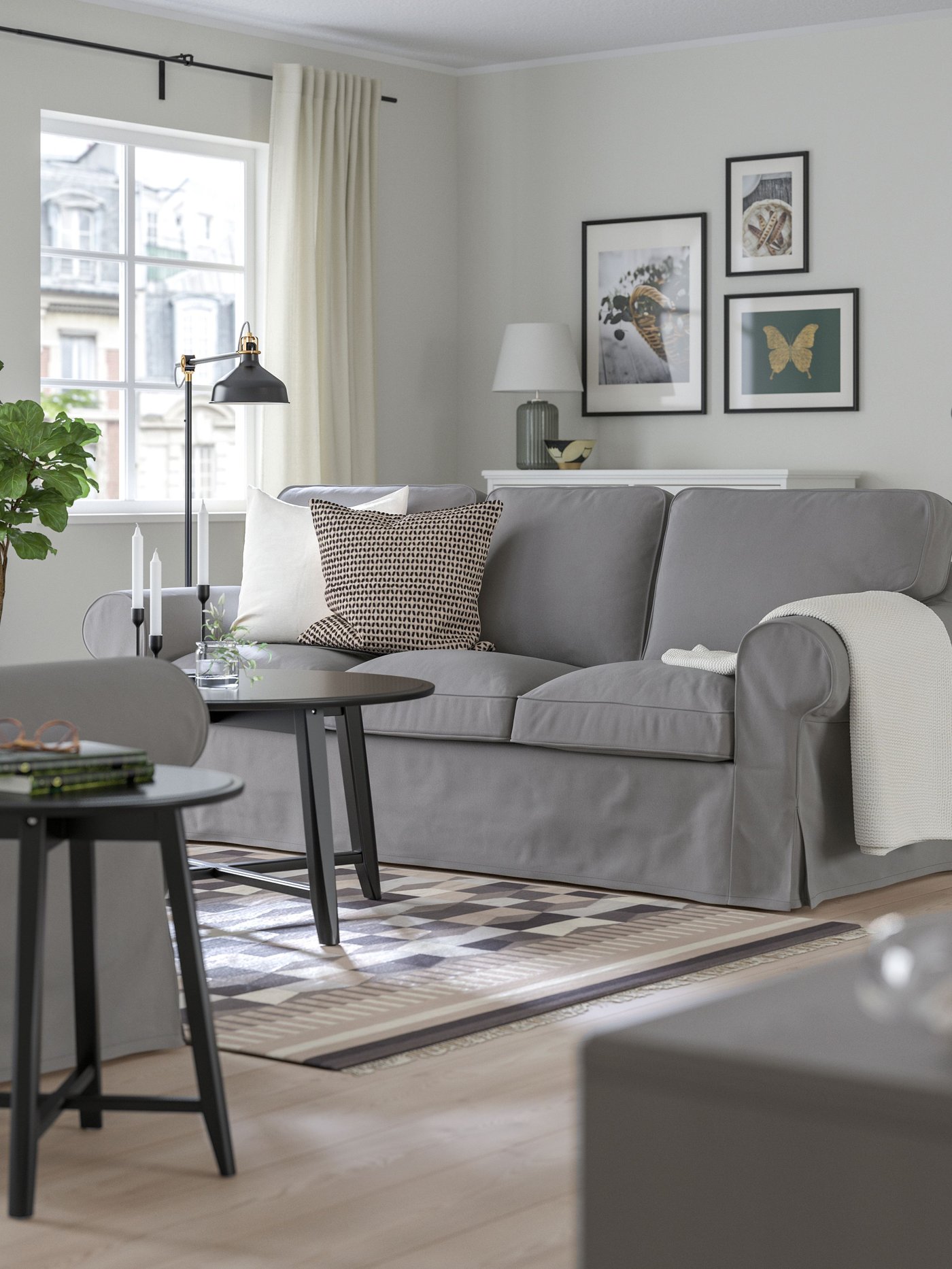 A Hakebo dark gray EKTORP 3-seater sofa with decorative cushions in a living room