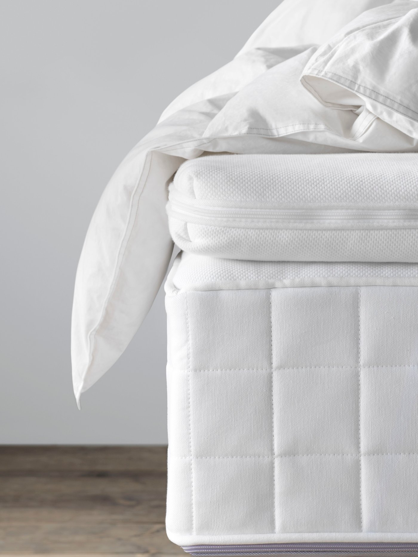 un surmatelas blanc posé sur un matelas