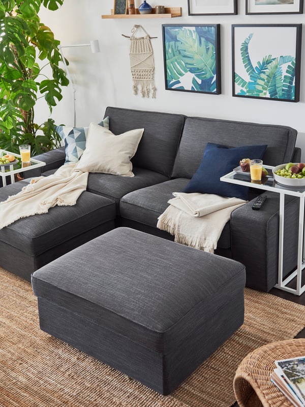 Un living con un sofá KIVIK y al costado derecho del sofá una mesa para notebook blanca de la serie VITTSJÖ.