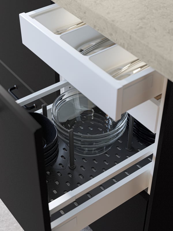 An open black kitchen drawer revealing bowls stacked in an UPPDATERA pegboard drawer organiser in anthracite.