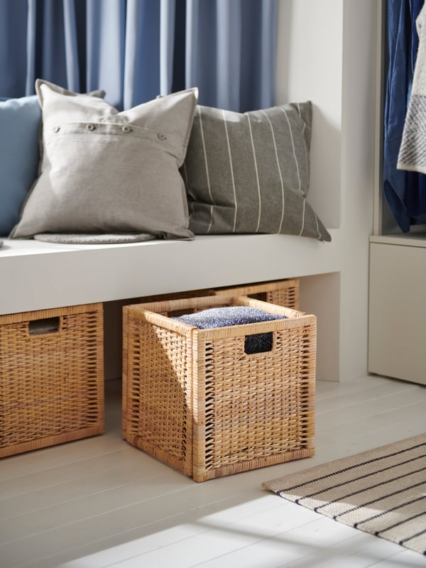 A beige AINA cushion cover in the hallway