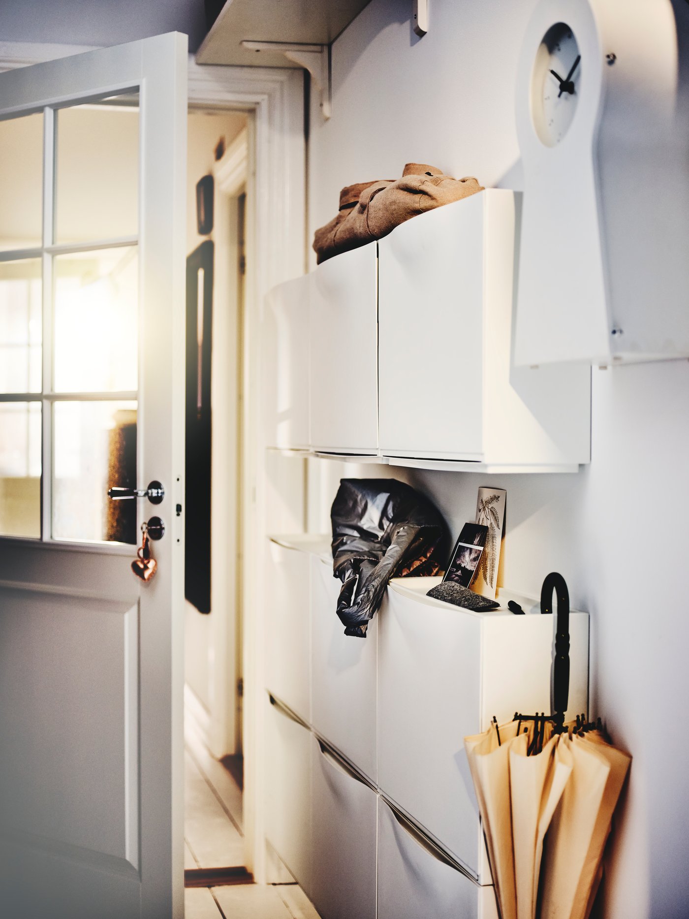 A white TRONES shoe cabinet/storage in the hallway