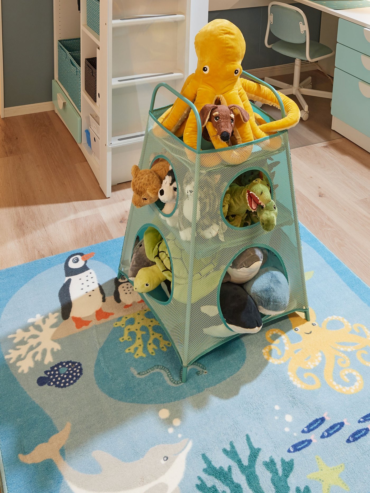 Una caja para juguetes con peluches BLÅVINGAD adentro.