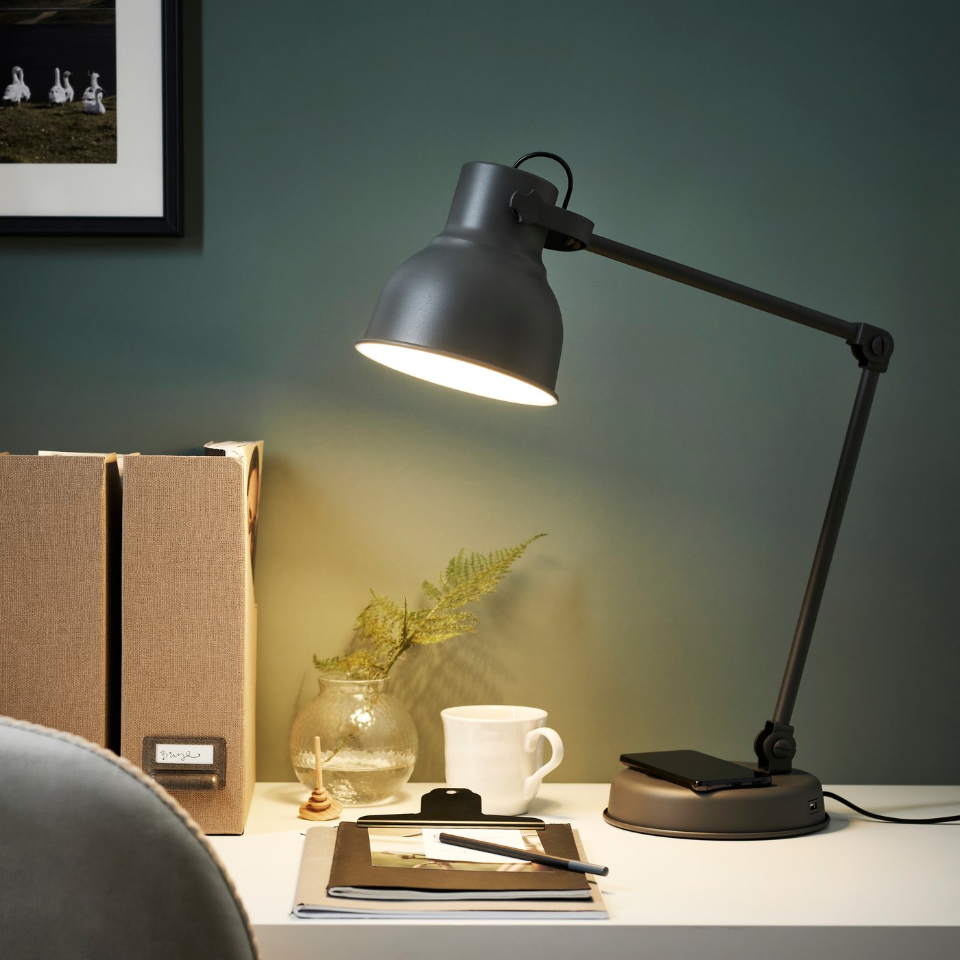 A dark grey HEKTAR desk lamp with a wireless charging function.