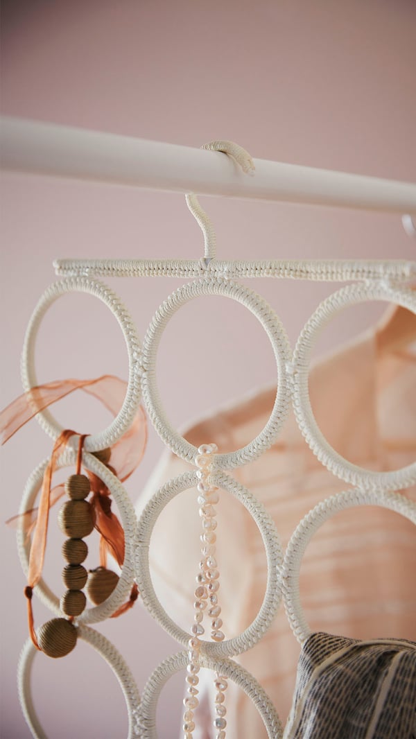 A white KOMPLEMENT multi-use hanger in the bedroom