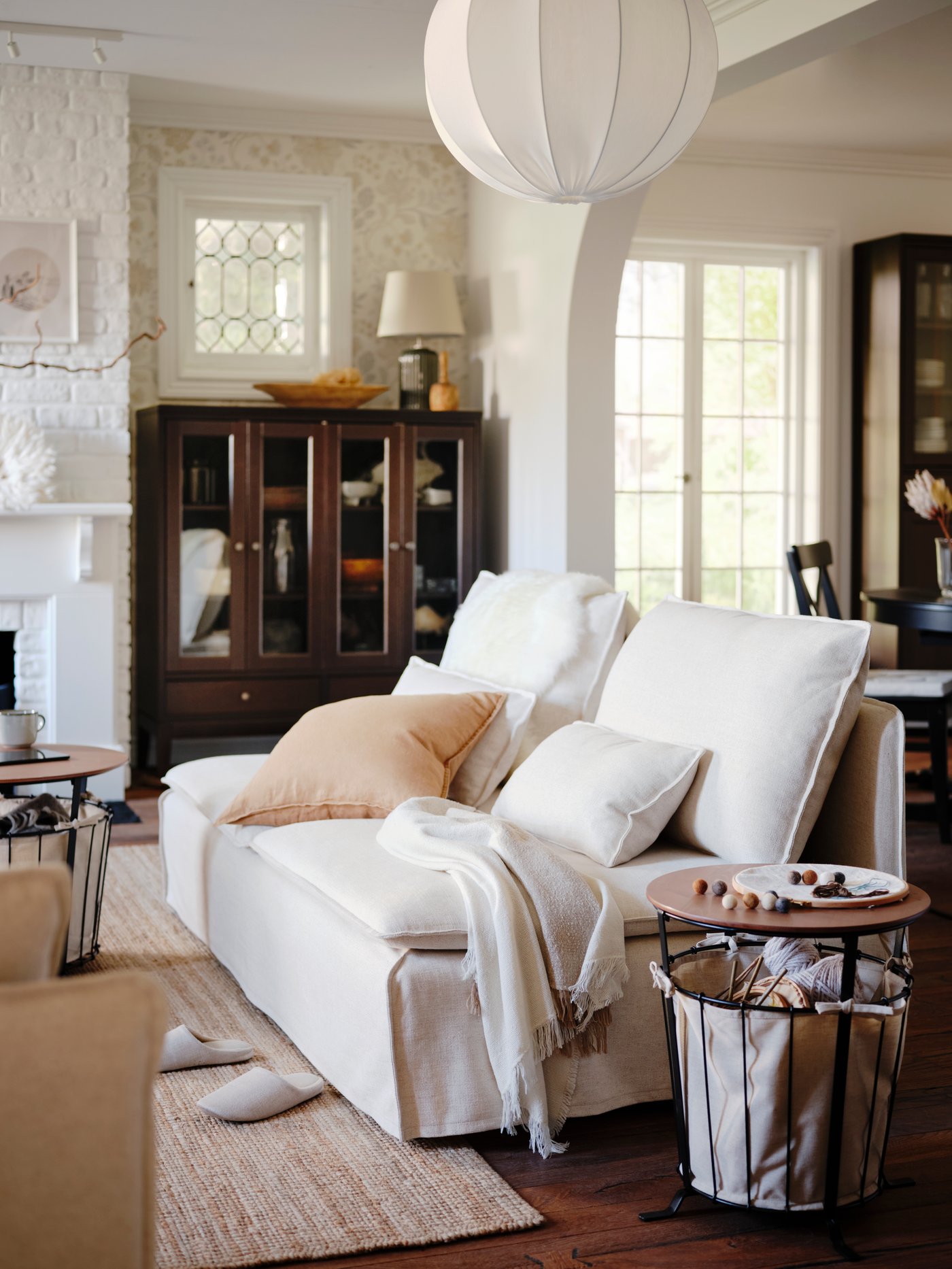 A white SÖDERHAMN sofa in a living room, with different cushions lying on it.