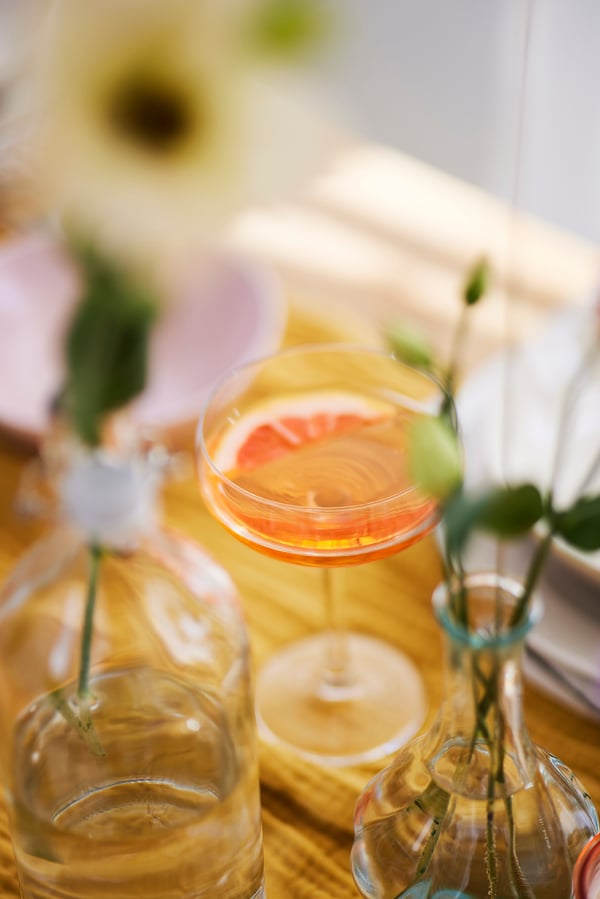 En drink står på et bord med en skive grape i