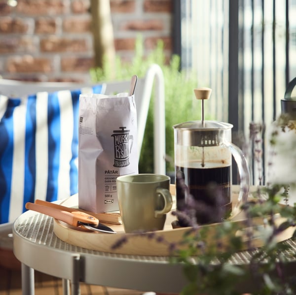 A coffee table is set on the balcony with a French press and PÅTÅR coffee for one.
