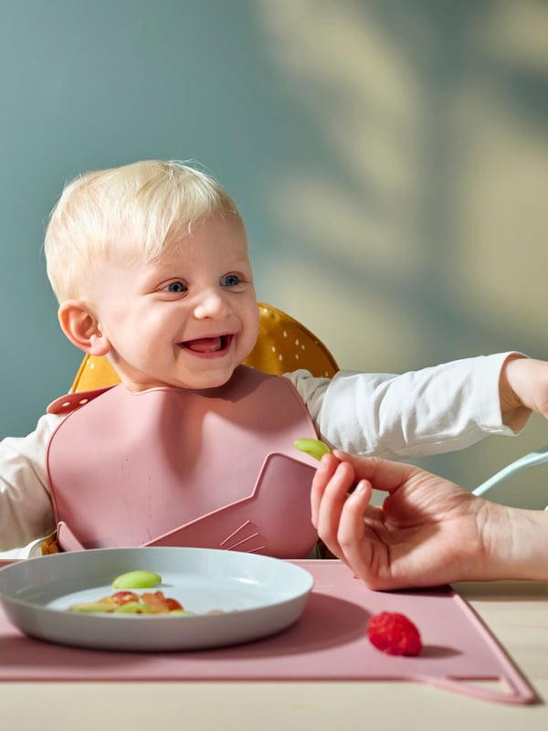 A pale pink GULDVÄVARE bib