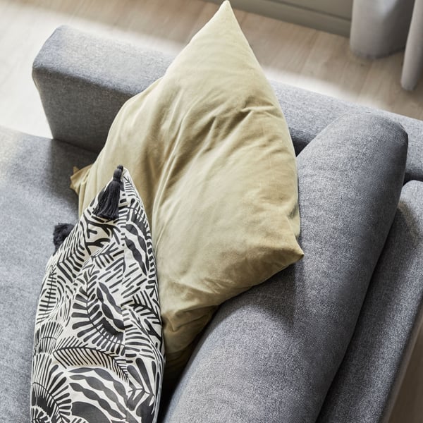 A light olive-green SANELA cushion cover in the living room