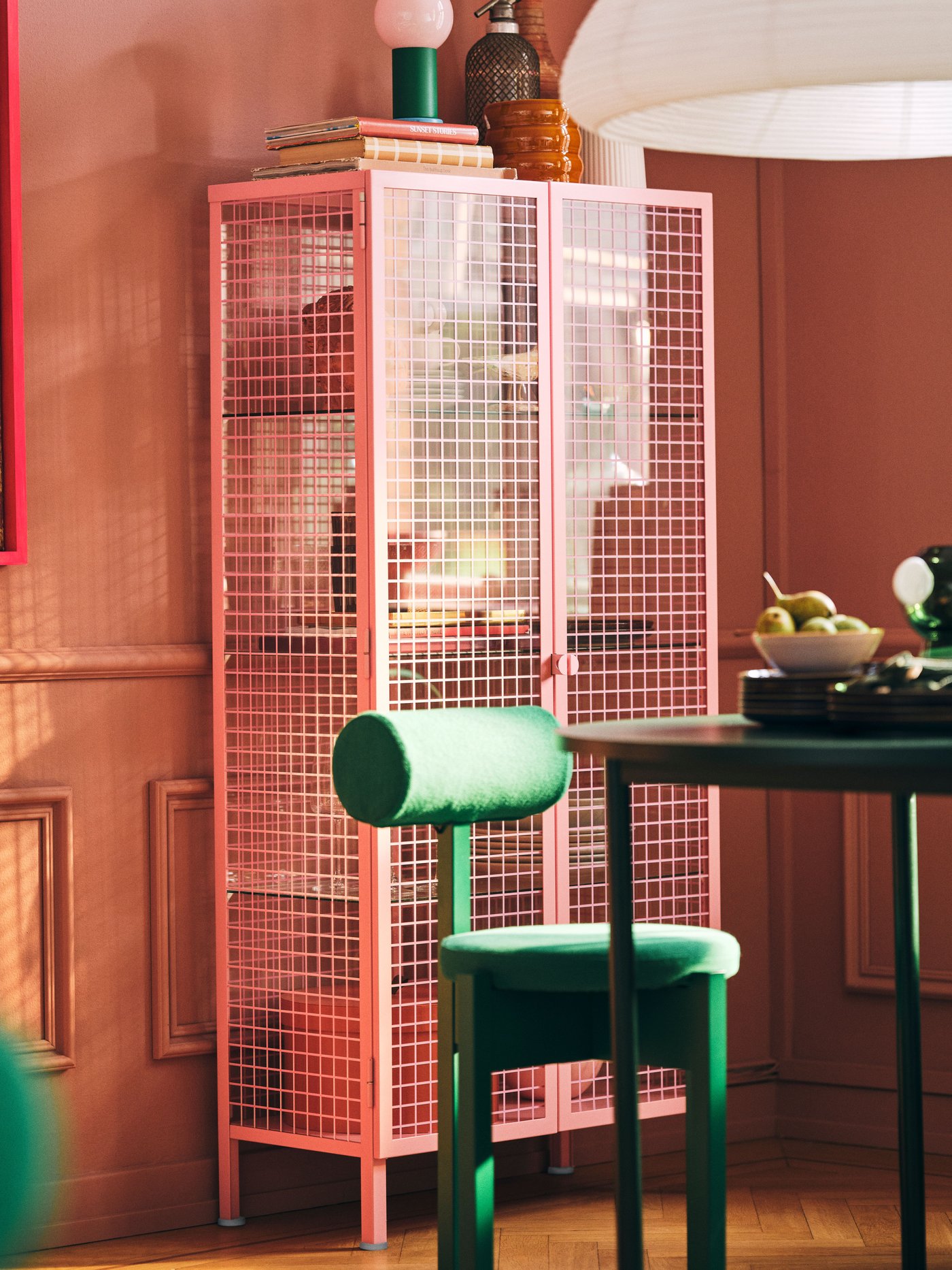 A light pink IKEA PS 2026 glass-door cabinet in the dining room
