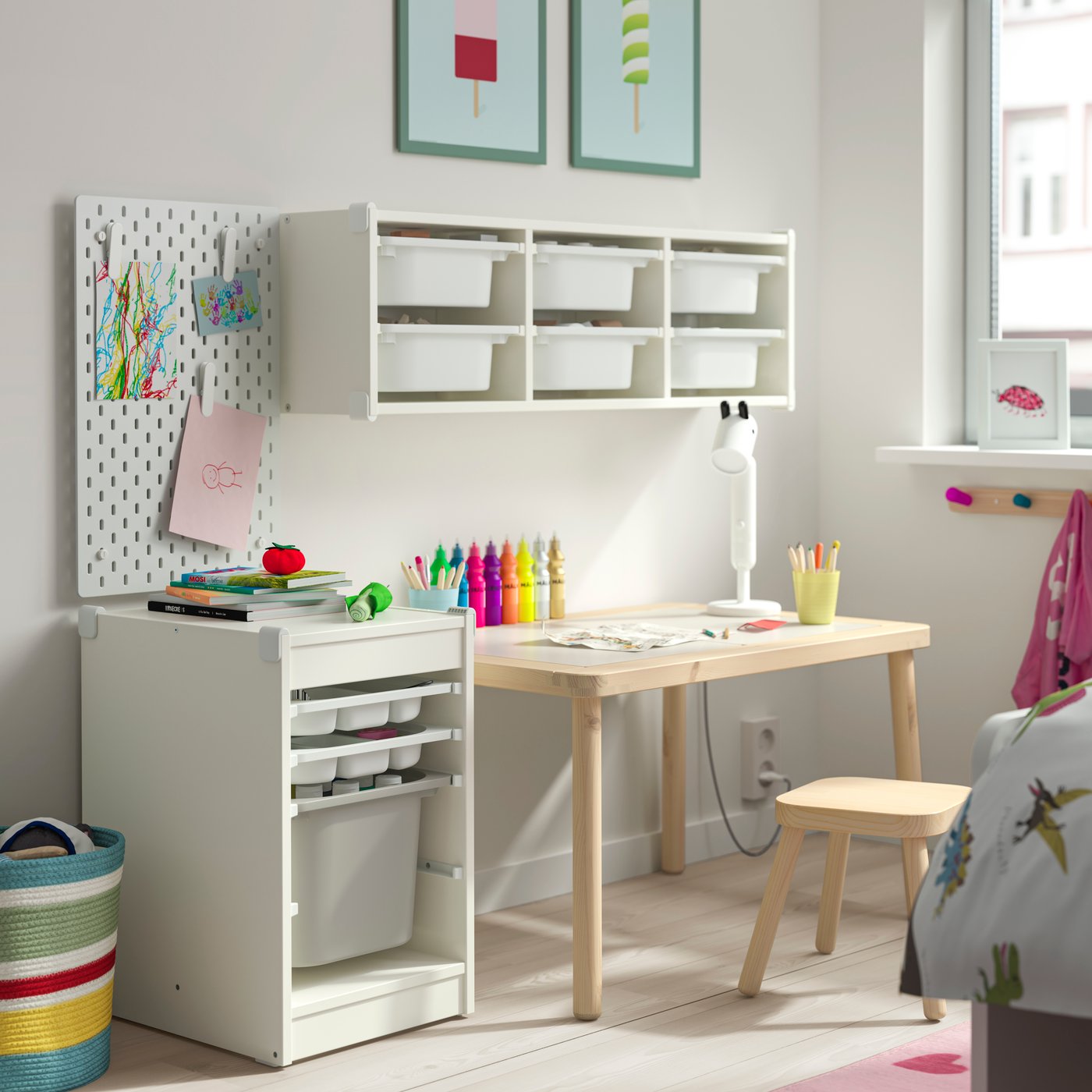 Un espacio de estudio enfantil con un escritorio de madera y en el costado un mueble TROFAST.