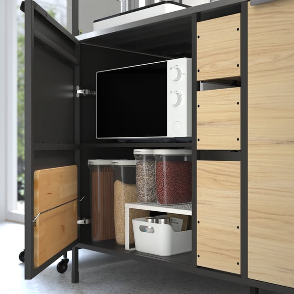 A black/ash ÄSPINGE kitchenette with food containers and a microwave.