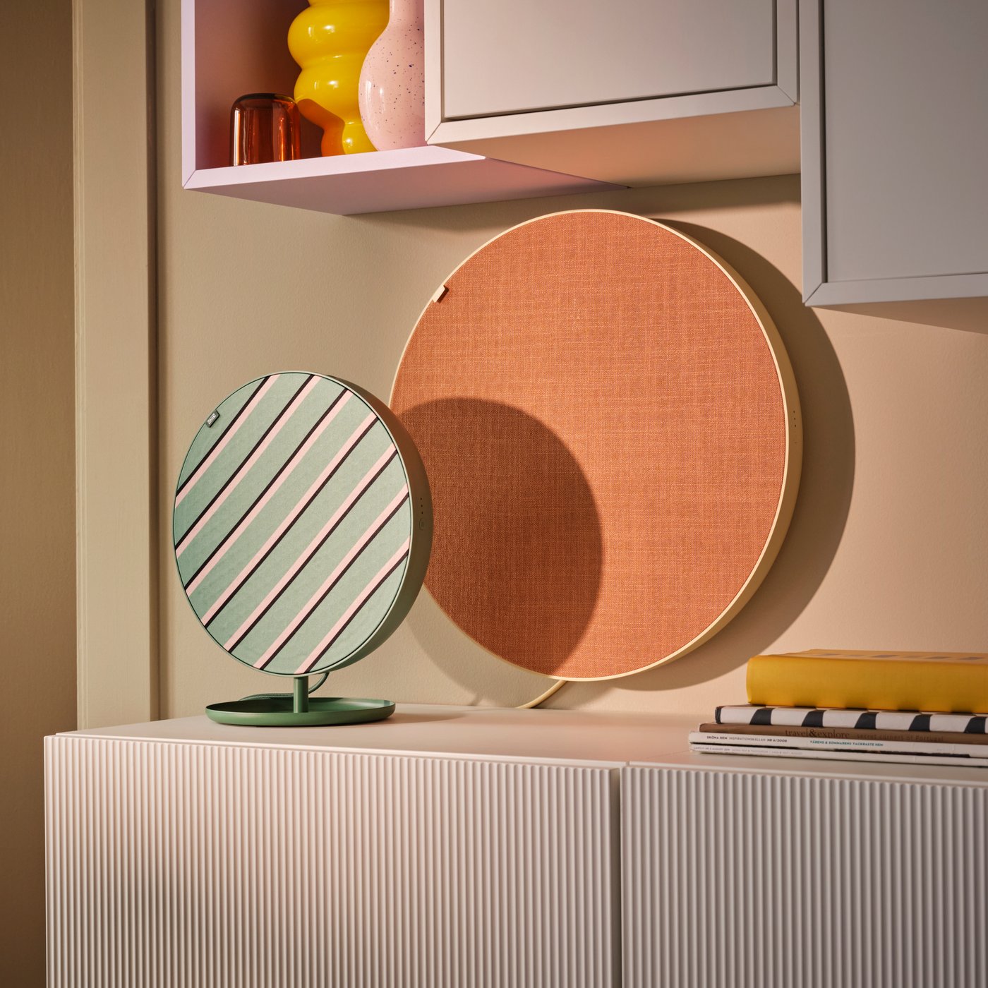 SOLSKYDD green standing portable speaker and SOLSKYDD orange and yellow speaker secured to the wall.