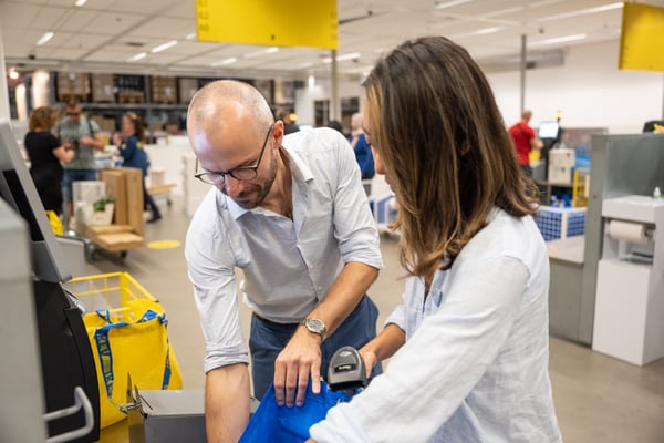 Dos personas sacando compras de una bolsa IKEA.