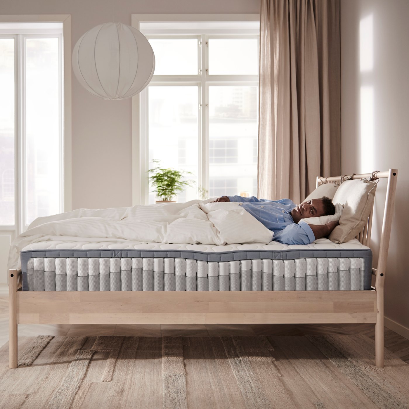 A firm/light blue VÅGSTRANDA pocket sprung mattress in the bedroom