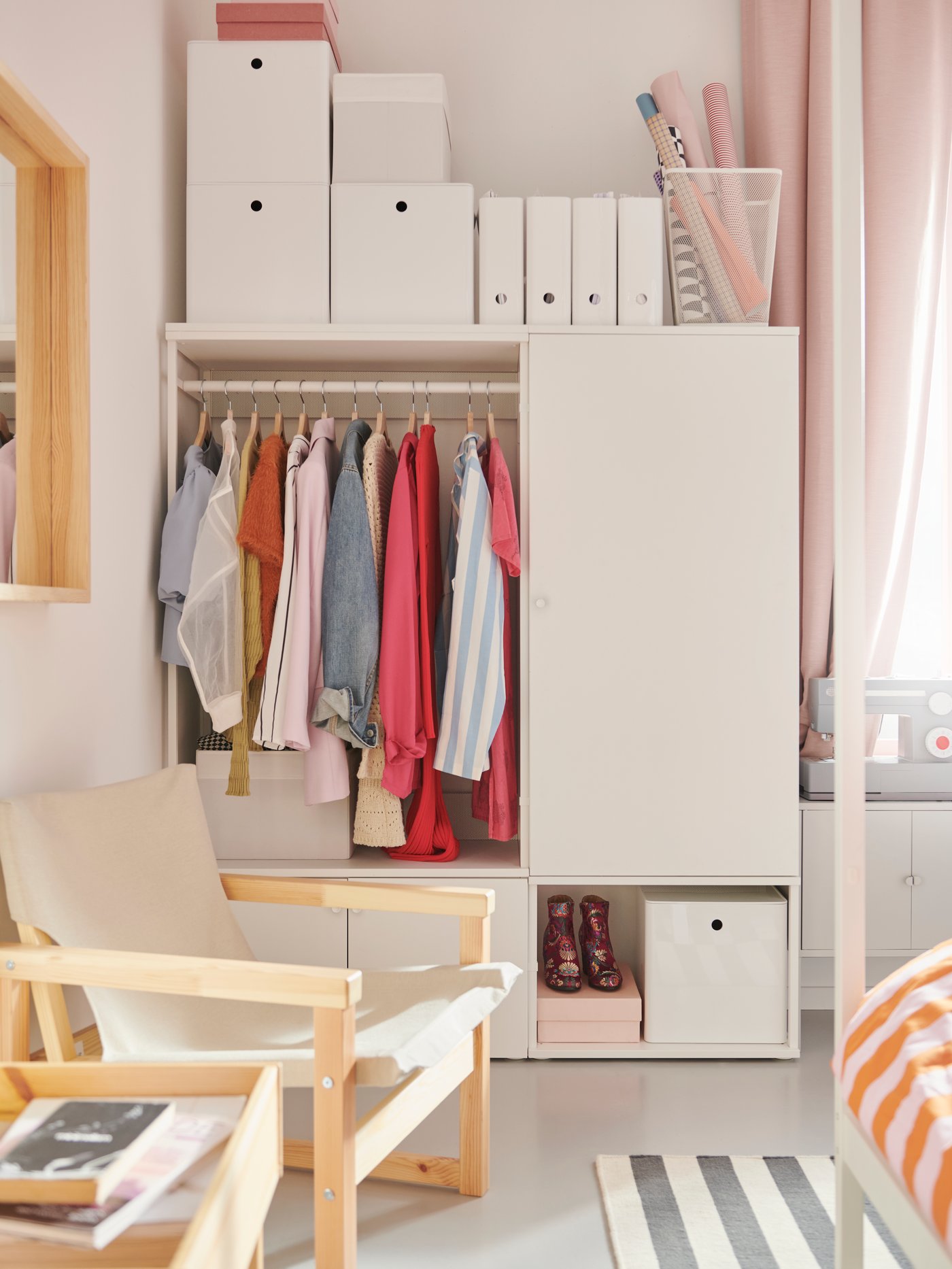 En kombination af åben og lukket PLATSA garderobe og opbevaringsenheder i hvid, mange kasser på toppen, stol i forgrunden.