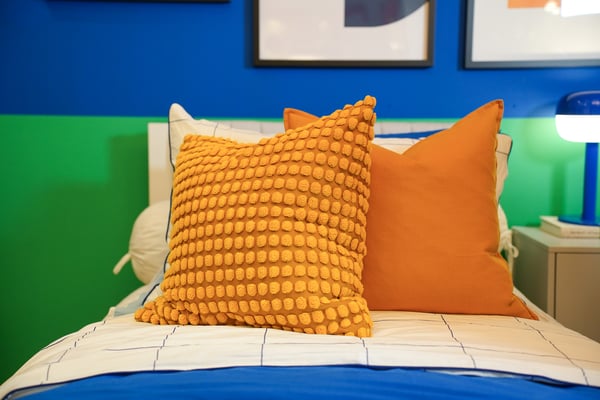 An yellow SVARTPOPPEL cushion cover