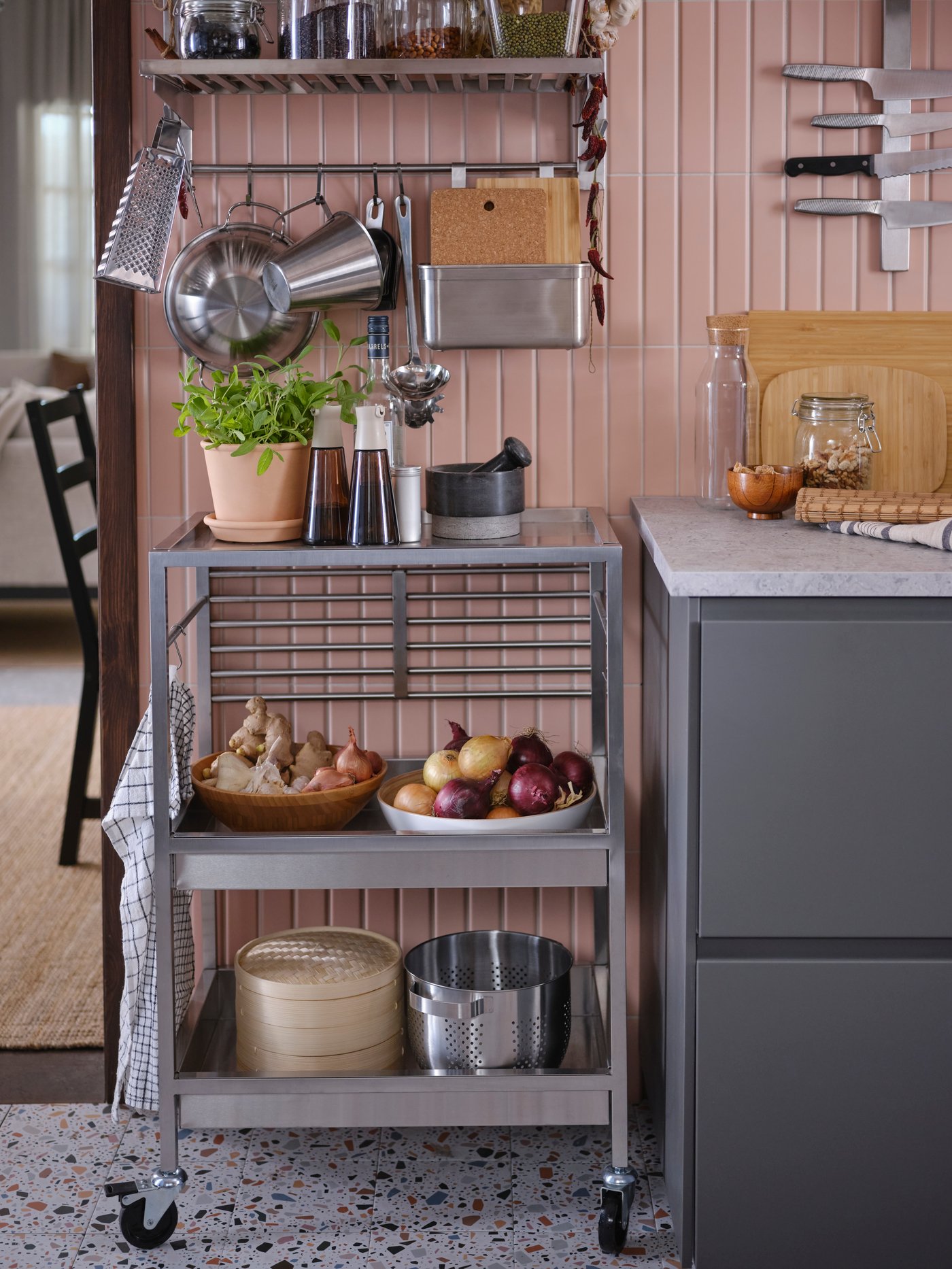 Various kitchenware on a kitchen trolley and a suspension rail with a shelf and rail in the stainless steel KUNGSFORS series.