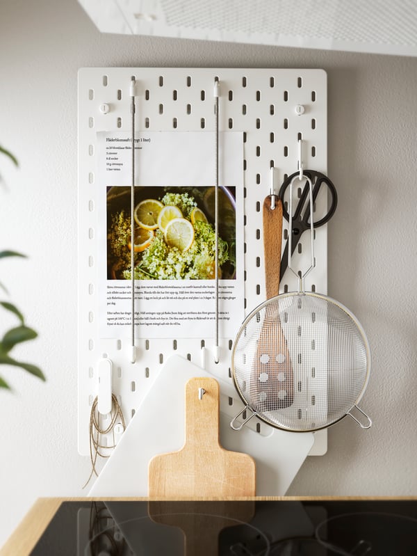 A white SKÅDIS pegboard in the kitchen