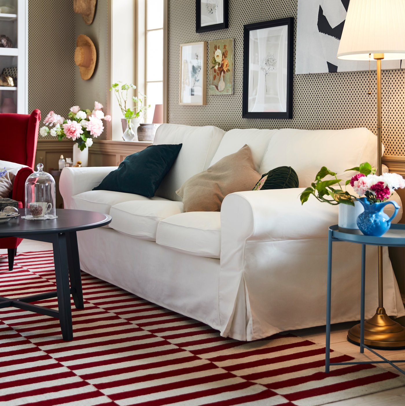 IKEA EKTORP white 3 seater sofa sitting on a red and white patterned rug in a living room