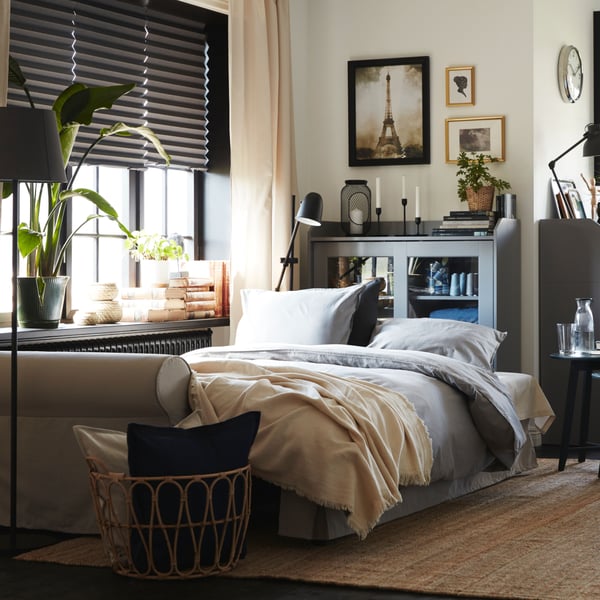 A natural colour/beige ODDRUN throw in the bedroom