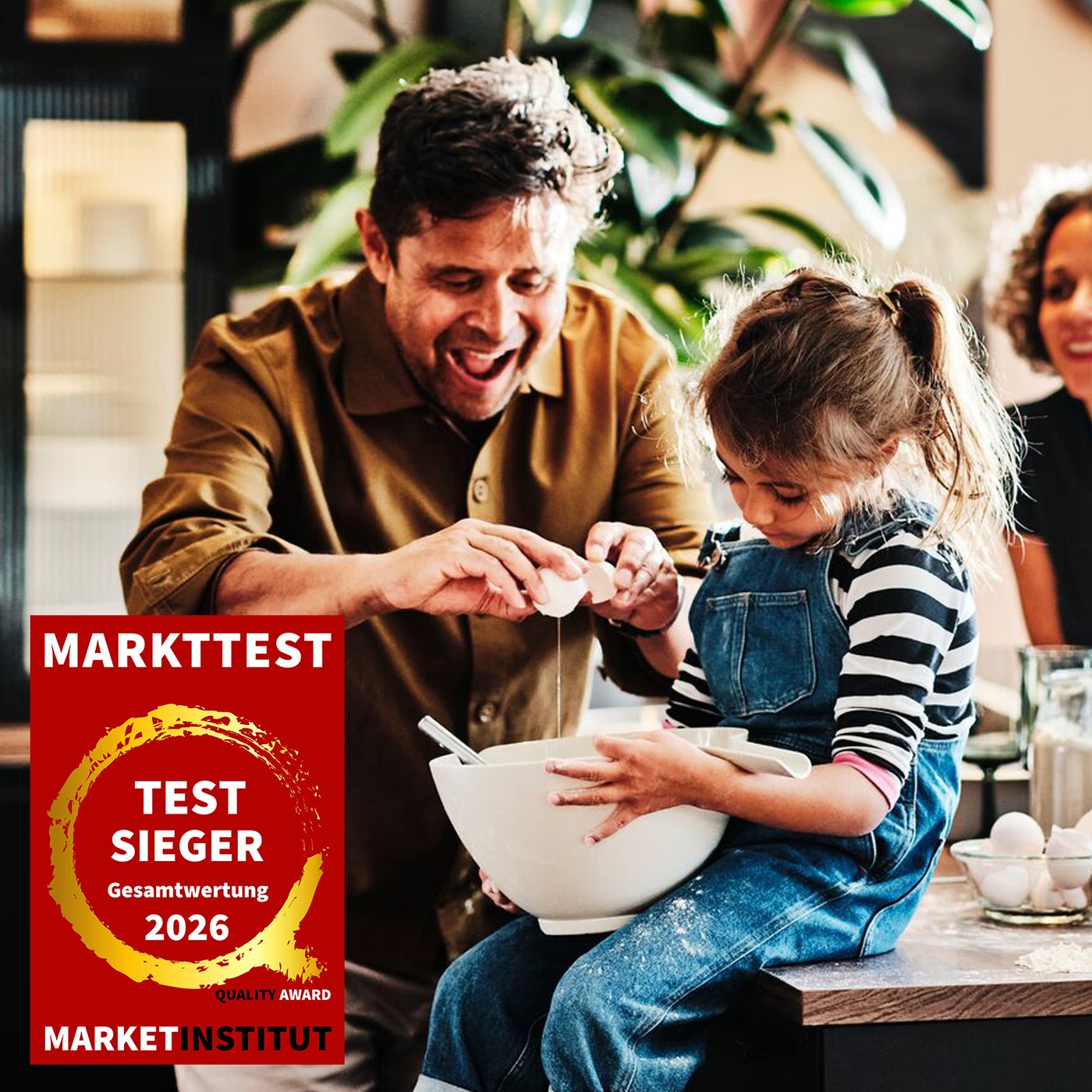 Man sieht einen Mann mit einem Kind beim Backen. Im Vordergrund sieht man das Markttest Logo mit dem Hinweis Testsieger Gesamtwertung 2026