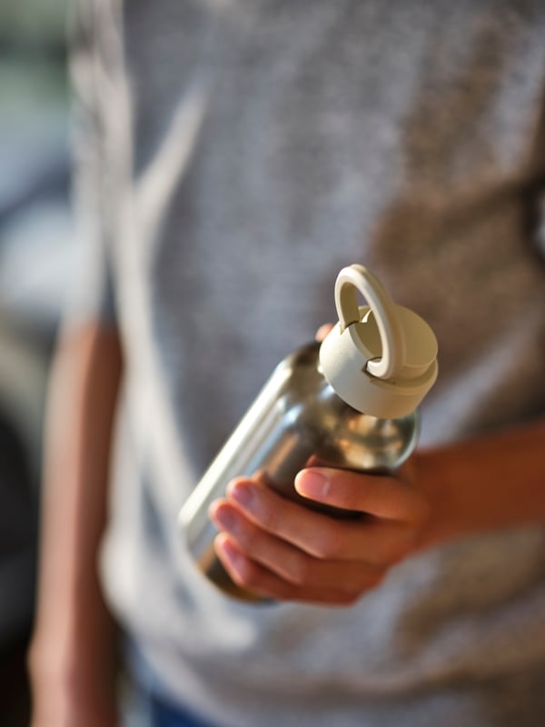 A stainless steel/beige ENKELSPÅRIG water bottle