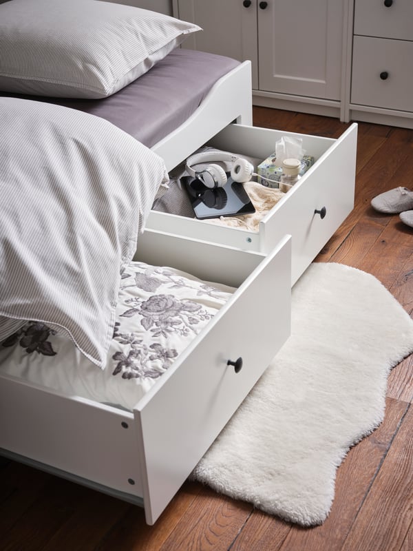 Beli TOFTLUND tepih na podu ispod dve otvorene fioke HEMNES dnevnog kreveta s 3 fioke/2 dušeka.