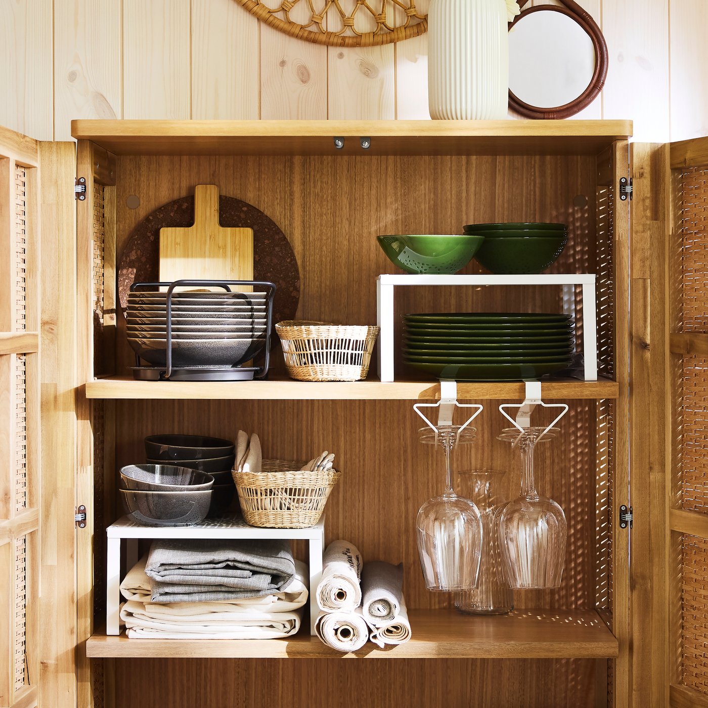 Many things, including plates, tablecloths and white VARIERA shelf inserts sit on the shelves of an open FRYKSÅS cabinet.