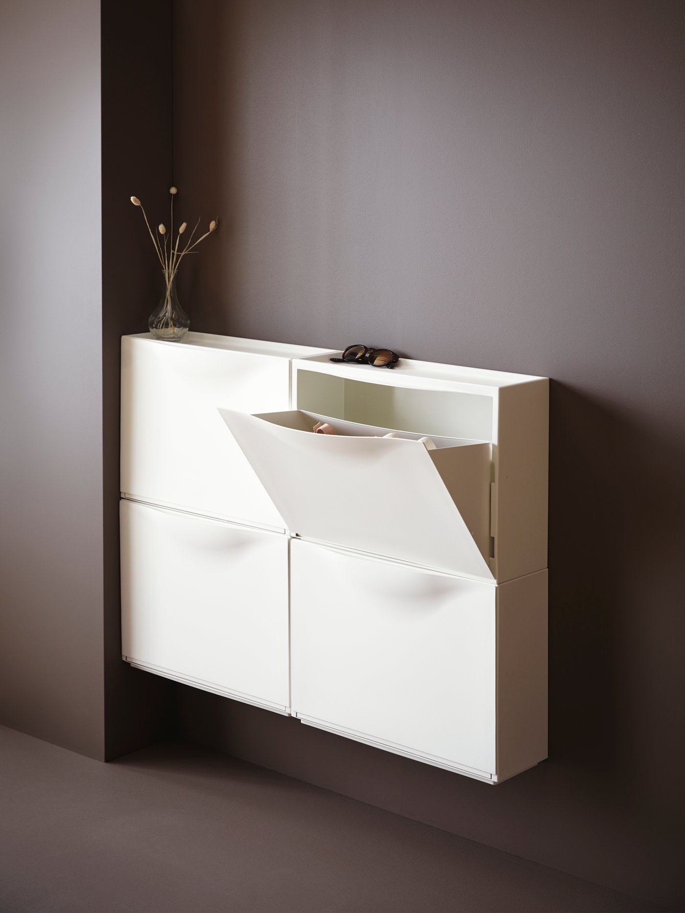 A white TRONES shoe cabinet/storage in the hallway