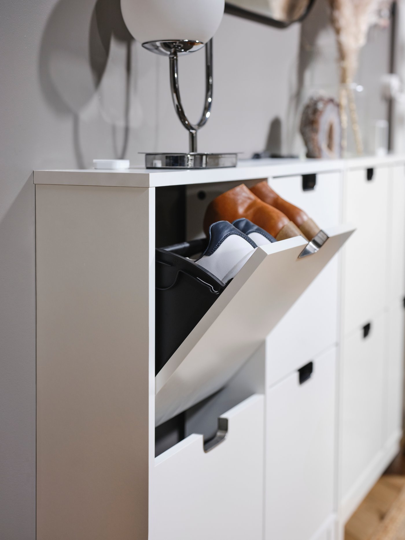 A white STÄLL shoe cabinet with 4 compartments in the hallway