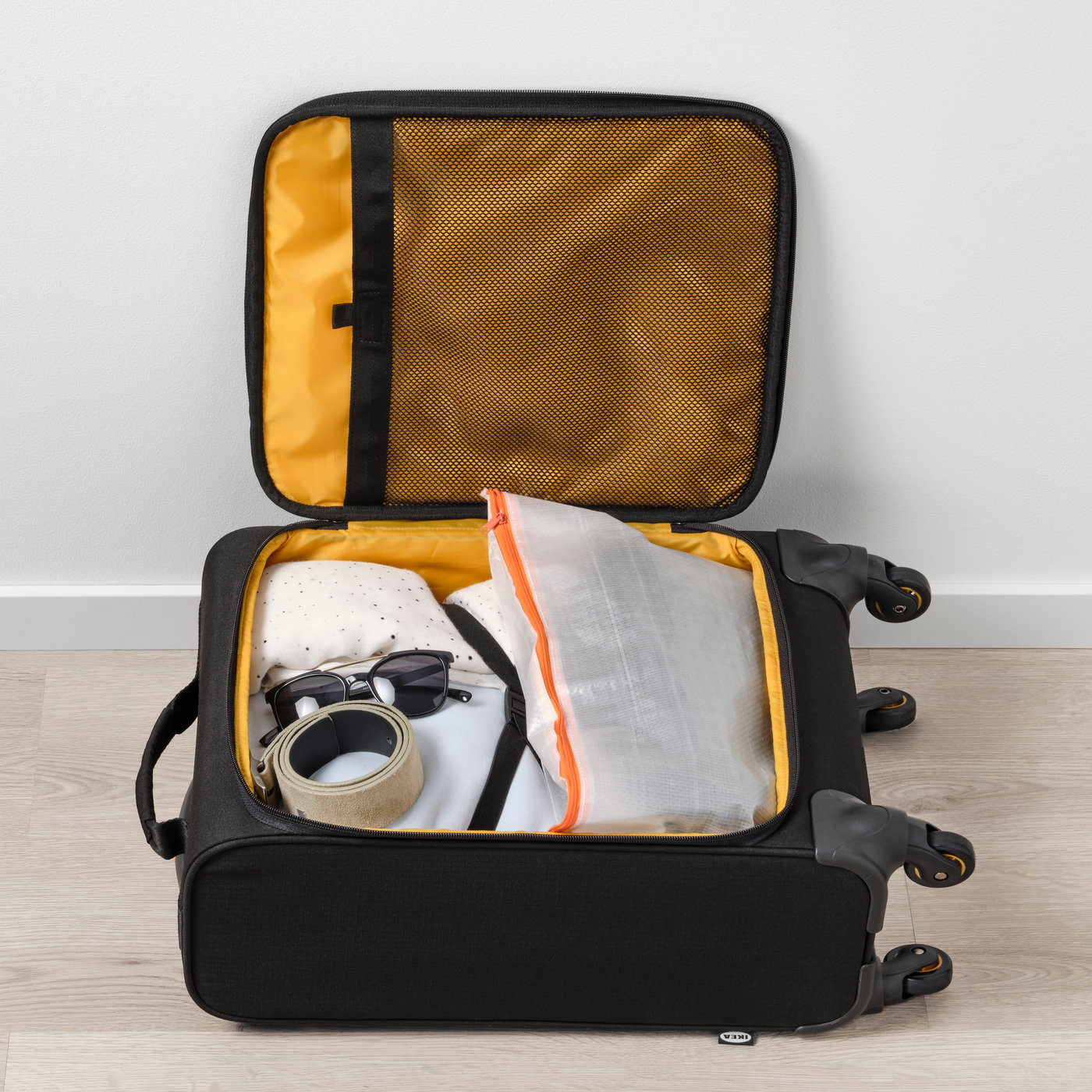 A black VÄRLDENS cabin bag on wheels with PÄRKLA bag organiser.