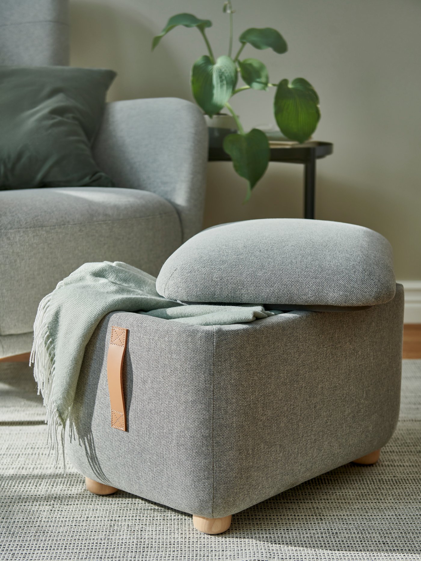 A light grey-green HOLMVI throw in the living room