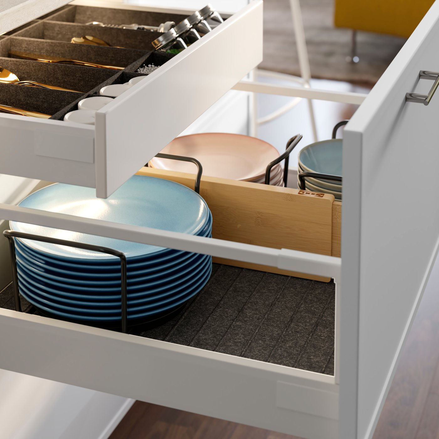 A close-up of a white VARIERA drawer divider in a kitchen drawer, storing plates and bowls tools in an neatly and organised.