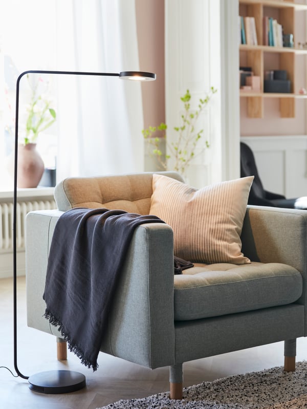 IKEA YPPERLIG LED black floor lamp, providing light to an LANDSKRONA armchair.