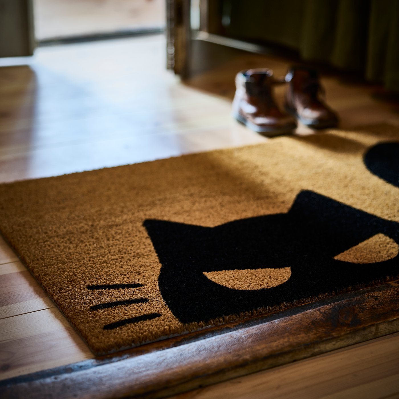 A cat pattern black/natural KUSTFYR door mat in the hallway
