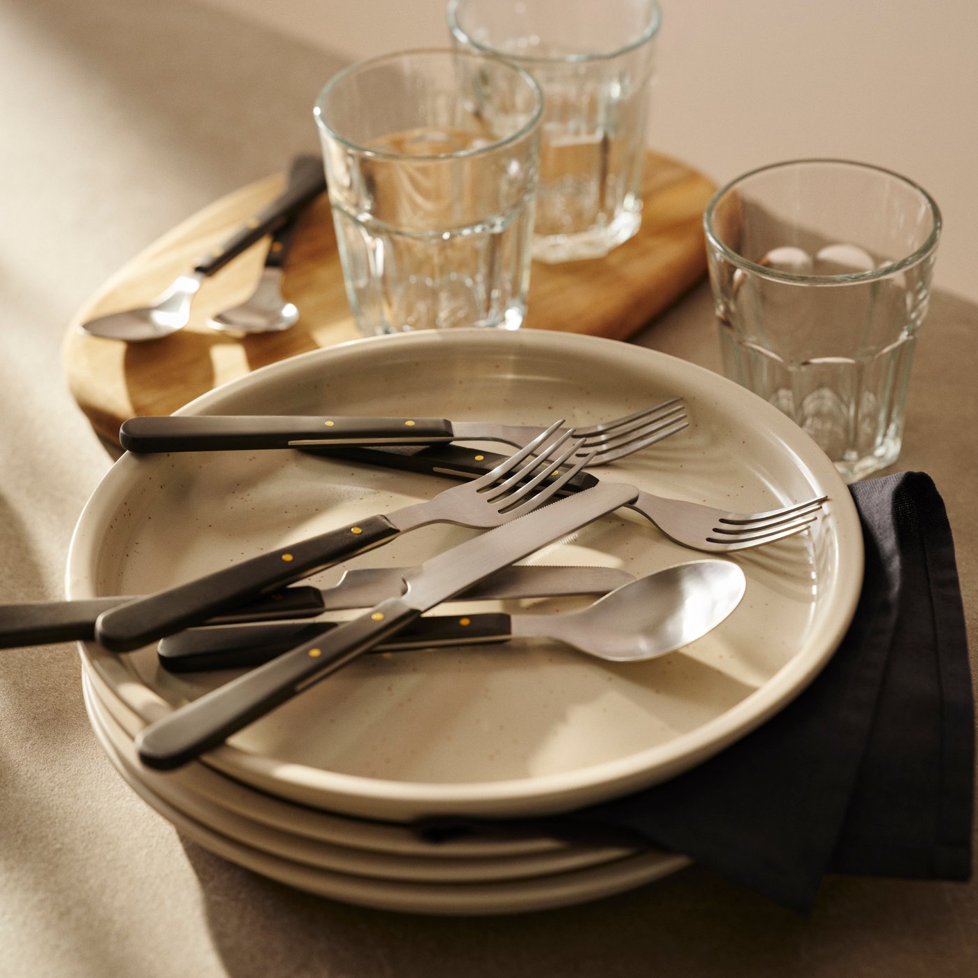 A black DOFTSKÖLD 24-piece cutlery set in the NA