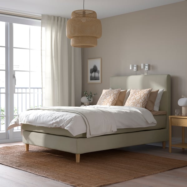 Ein HEMFJÄLLET Polsterbett ist in einem hellen Schlafzimmer zu sehen.