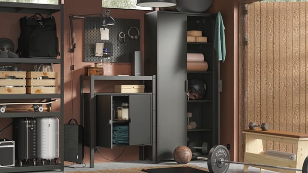 A neatly arranged garage wall with equipment and accessories in a black BROR storage combination, lit by a TERTIAL work lamp.